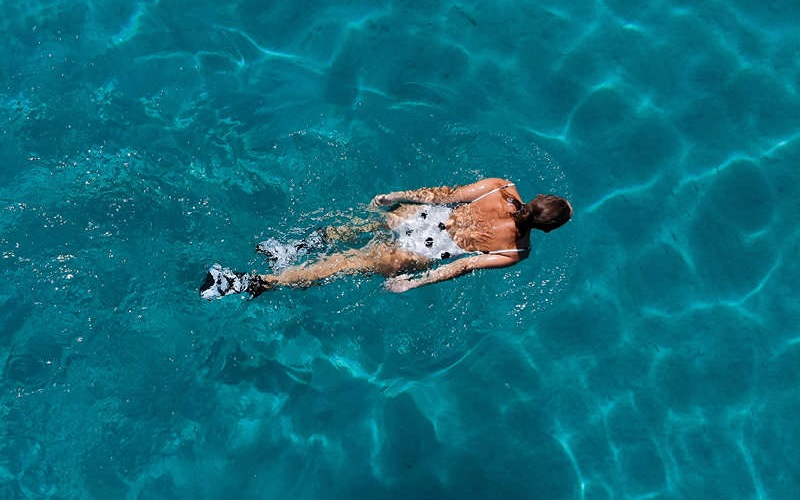 overhead shot of woman swimming in a pool